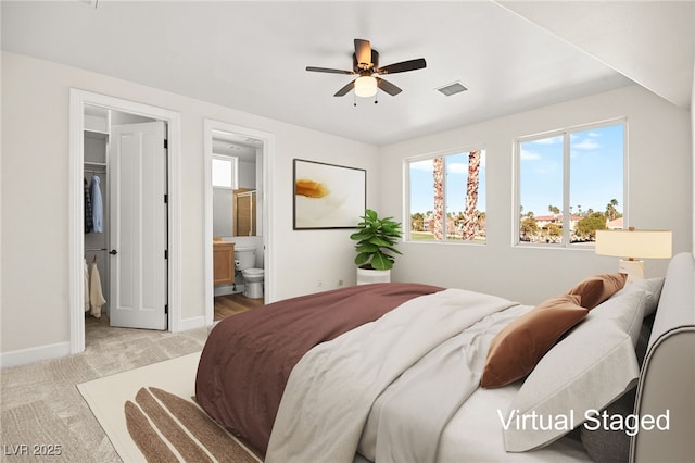 carpeted bedroom featuring ceiling fan and ensuite bath