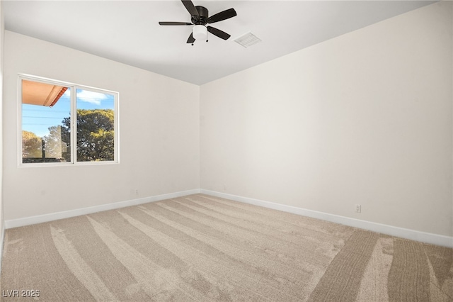 carpeted spare room featuring ceiling fan