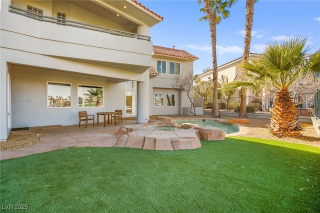 back of house featuring a fenced in pool, a patio, and a lawn