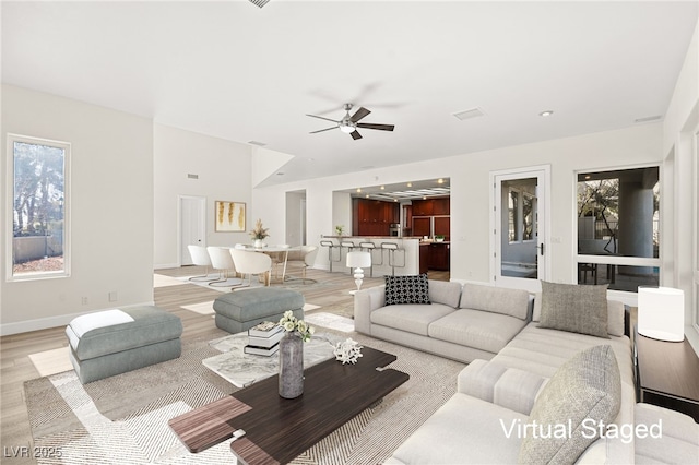 living room featuring ceiling fan and light hardwood / wood-style floors