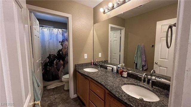 bathroom featuring vanity, tile patterned flooring, and toilet