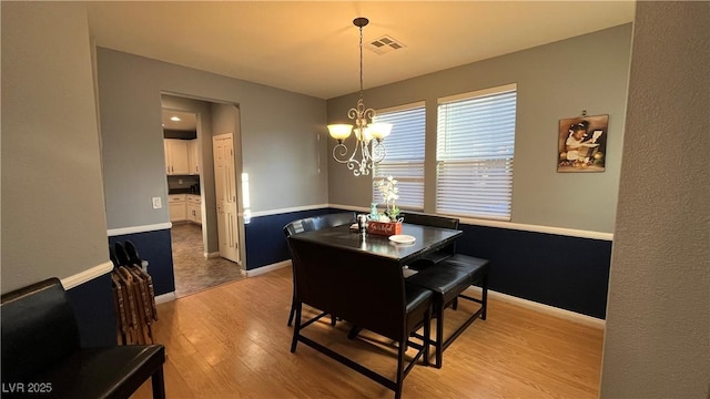 dining space featuring an inviting chandelier and light wood-type flooring