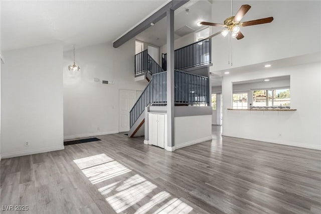 unfurnished living room featuring wood-type flooring, high vaulted ceiling, and ceiling fan