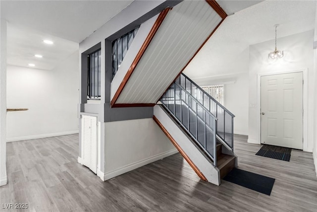 stairway featuring wood-type flooring and a chandelier