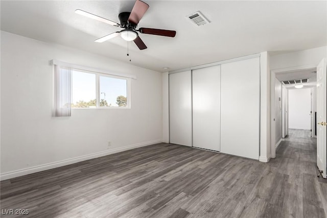 unfurnished bedroom featuring hardwood / wood-style flooring, a closet, and ceiling fan