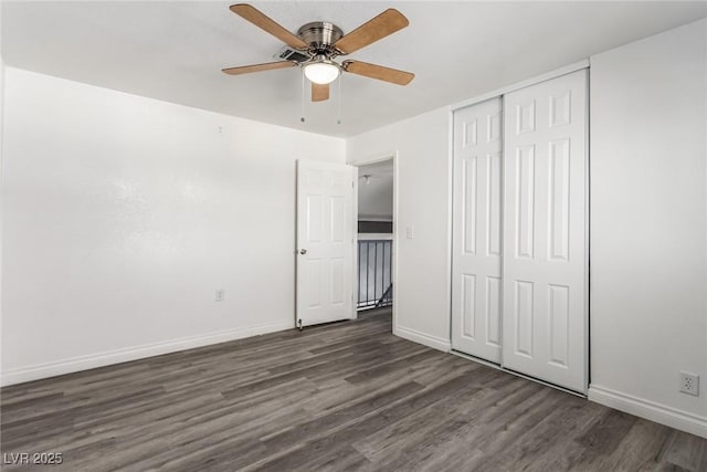 unfurnished bedroom with dark hardwood / wood-style flooring, a closet, and ceiling fan