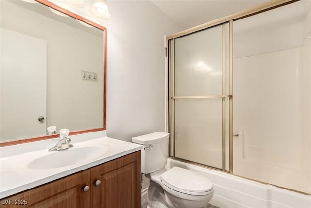 full bathroom with vanity, bath / shower combo with glass door, and toilet