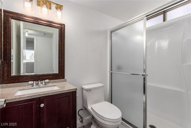 bathroom featuring an enclosed shower, vanity, and toilet