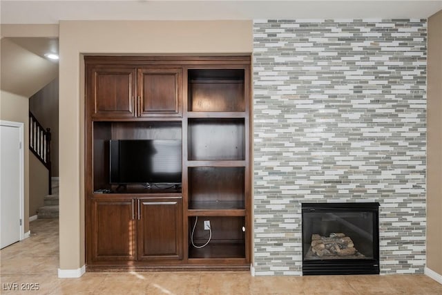 unfurnished living room featuring light tile patterned floors and a tile fireplace