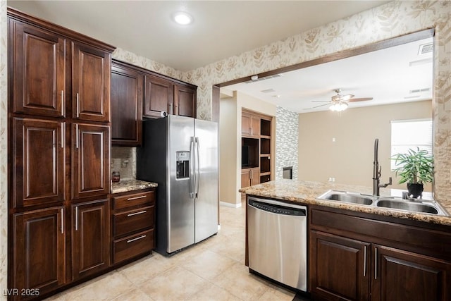 kitchen featuring appliances with stainless steel finishes, sink, light tile patterned floors, dark brown cabinetry, and ceiling fan