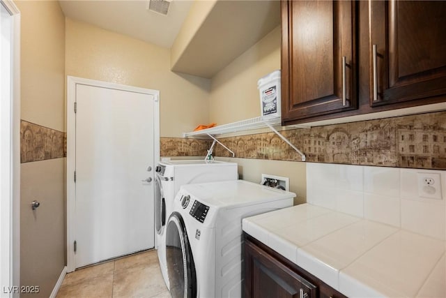 laundry area with cabinets, light tile patterned flooring, and washer and dryer