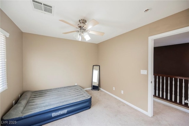 bedroom featuring multiple windows, light carpet, and ceiling fan