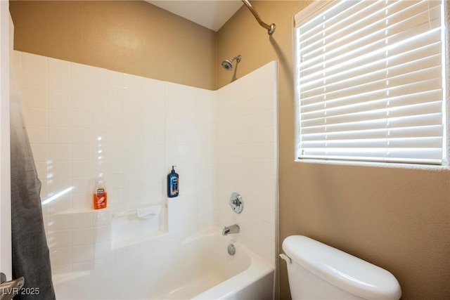 bathroom featuring shower / tub combo and toilet