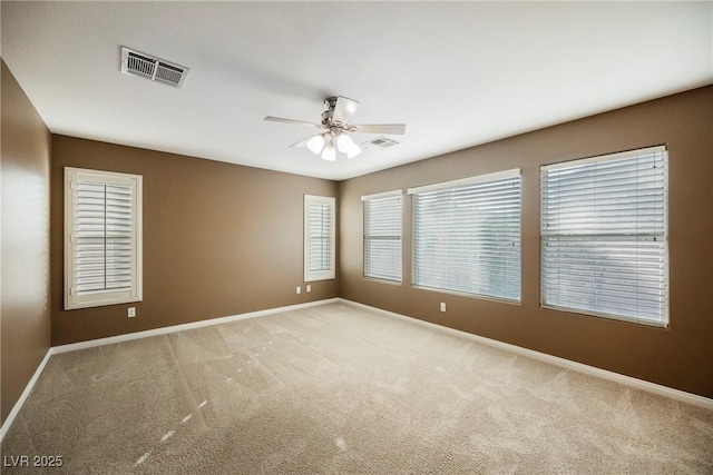 carpeted spare room with ceiling fan