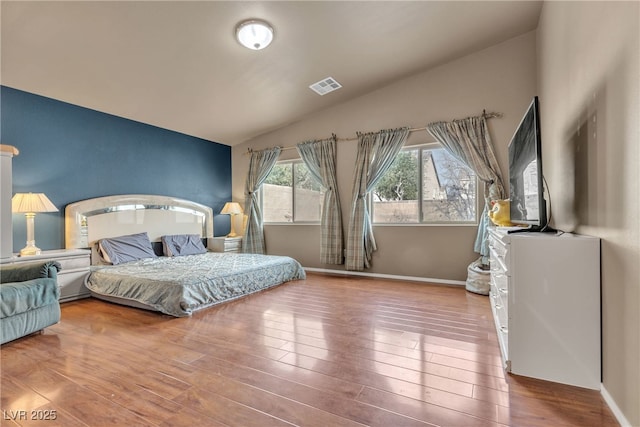 bedroom featuring lofted ceiling and hardwood / wood-style floors