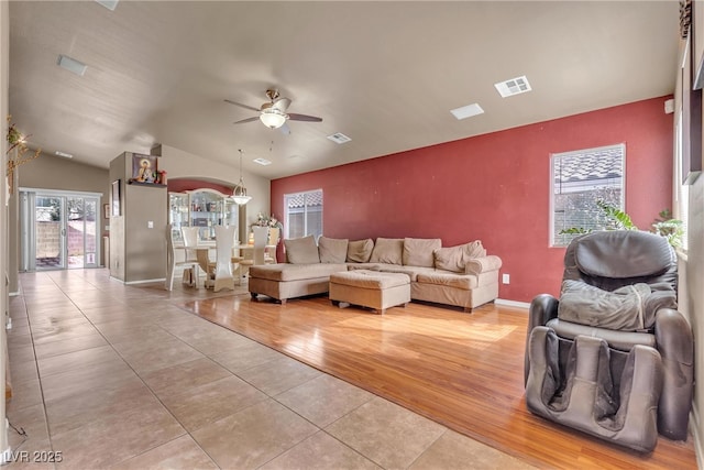 living room featuring a healthy amount of sunlight, vaulted ceiling, light hardwood / wood-style floors, and ceiling fan