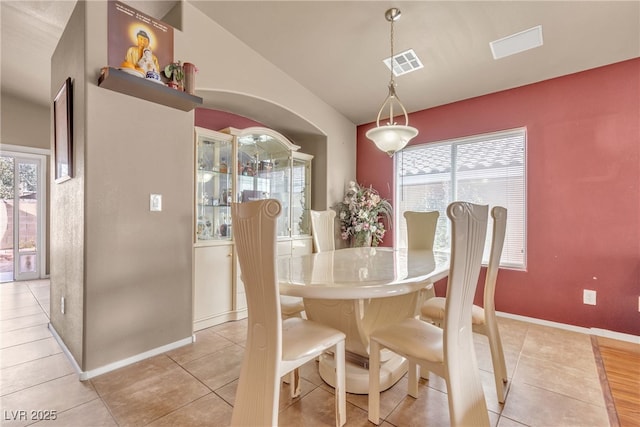 tiled dining space with vaulted ceiling and a wealth of natural light