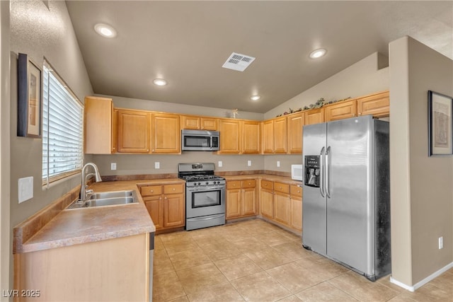 kitchen with lofted ceiling, sink, light tile patterned floors, appliances with stainless steel finishes, and light brown cabinetry