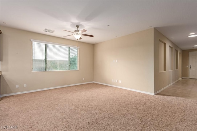 unfurnished room with light carpet, baseboards, visible vents, and ceiling fan