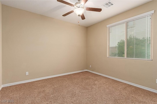 carpeted spare room featuring visible vents, ceiling fan, and baseboards