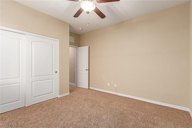 unfurnished bedroom with a closet, light colored carpet, visible vents, a ceiling fan, and baseboards