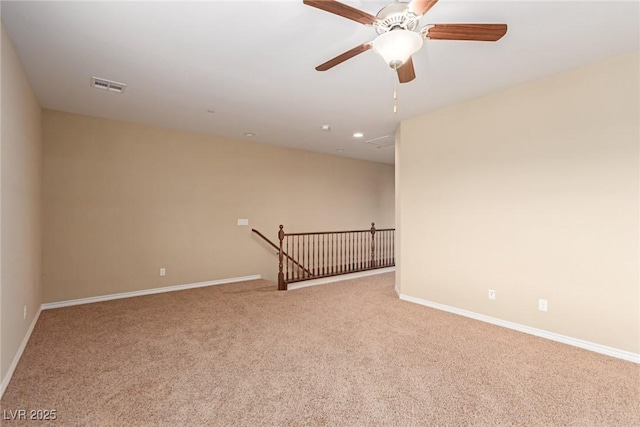 spare room featuring carpet, visible vents, and baseboards