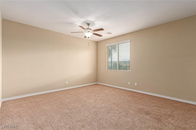 empty room with carpet flooring, ceiling fan, visible vents, and baseboards