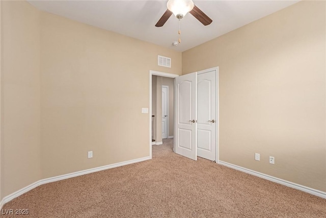 unfurnished bedroom featuring light carpet, baseboards, visible vents, and ceiling fan