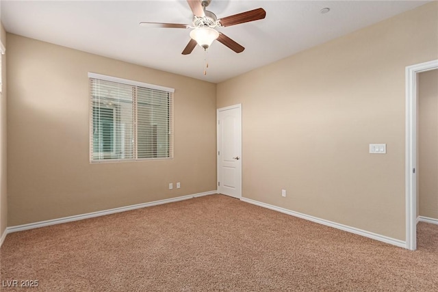 carpeted spare room featuring ceiling fan and baseboards