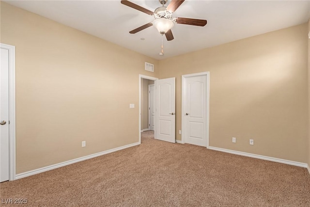 carpeted empty room with a ceiling fan, visible vents, and baseboards