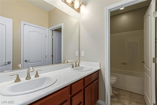 bathroom with a sink, toilet, and double vanity