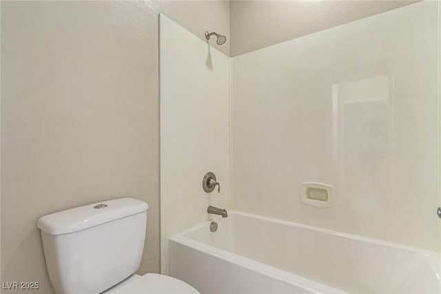 bathroom featuring washtub / shower combination and toilet