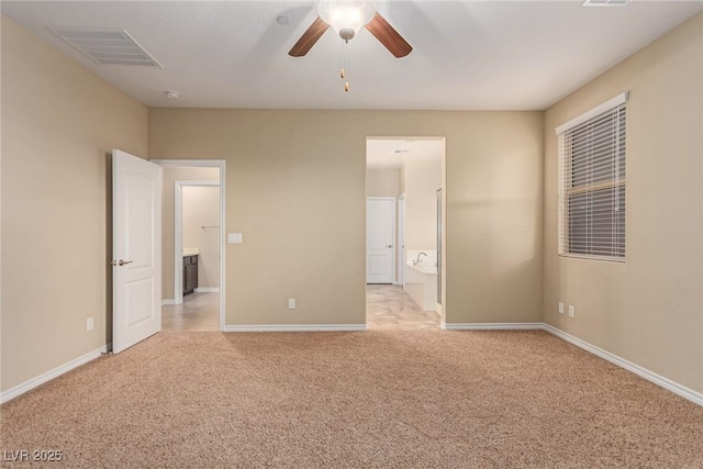 unfurnished bedroom with baseboards, ensuite bathroom, visible vents, and light colored carpet