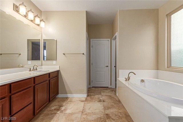 bathroom featuring a garden tub, vanity, and baseboards