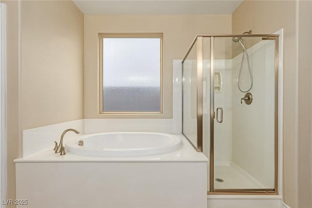 bathroom featuring a stall shower and a bath