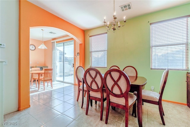 tiled dining space with a chandelier