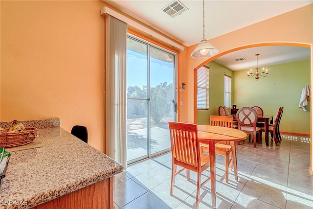 dining space featuring light tile patterned flooring and a chandelier