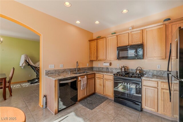 kitchen featuring light tile patterned floors, light stone countertops, sink, and black appliances