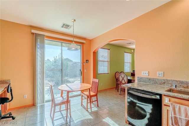 tiled dining space featuring sink and a healthy amount of sunlight