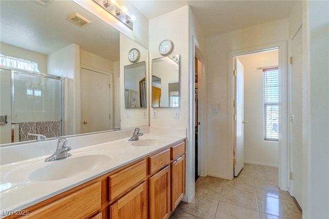 bathroom featuring vanity, tile patterned floors, and a shower with shower door