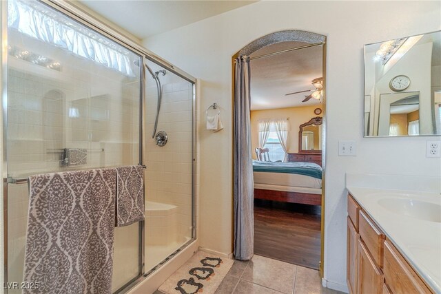 bathroom with tile patterned flooring, an enclosed shower, vanity, and ceiling fan