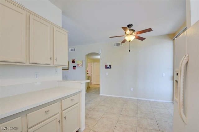 kitchen with cream cabinets, white refrigerator with ice dispenser, ceiling fan, and light tile patterned floors