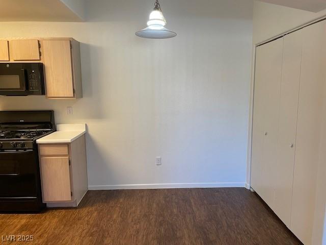 kitchen featuring hanging light fixtures, dark wood-type flooring, light brown cabinetry, and black appliances