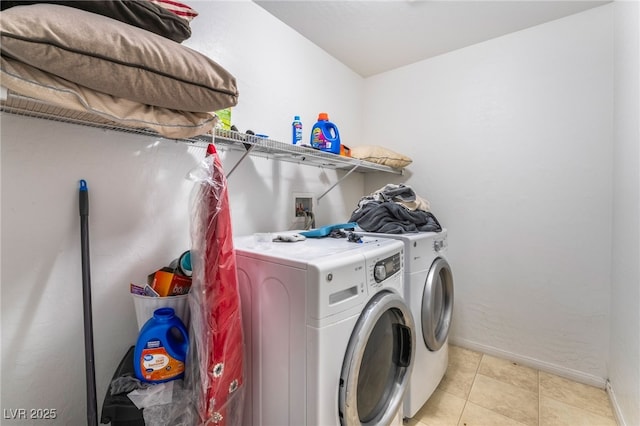 laundry room with independent washer and dryer and light tile patterned floors