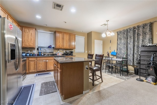 kitchen with pendant lighting, a breakfast bar, an inviting chandelier, stainless steel appliances, and a center island