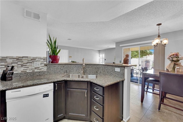 kitchen featuring dishwasher, sink, kitchen peninsula, light stone countertops, and dark brown cabinets