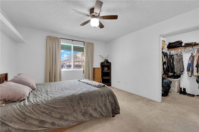 carpeted bedroom featuring ceiling fan, a spacious closet, a closet, and a textured ceiling