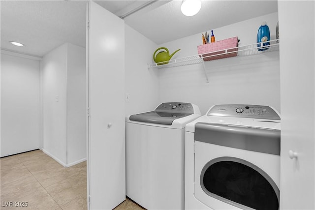 laundry area with light tile patterned floors and washer and dryer