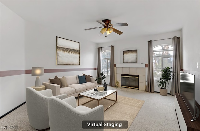 living room featuring a tile fireplace and ceiling fan