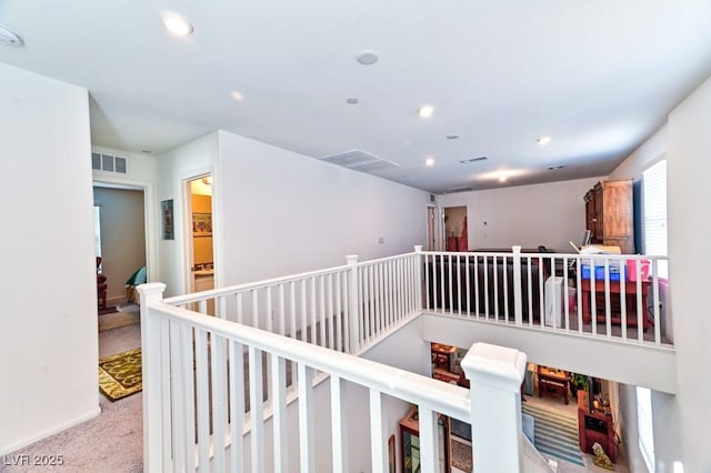 hall with light colored carpet and a wealth of natural light